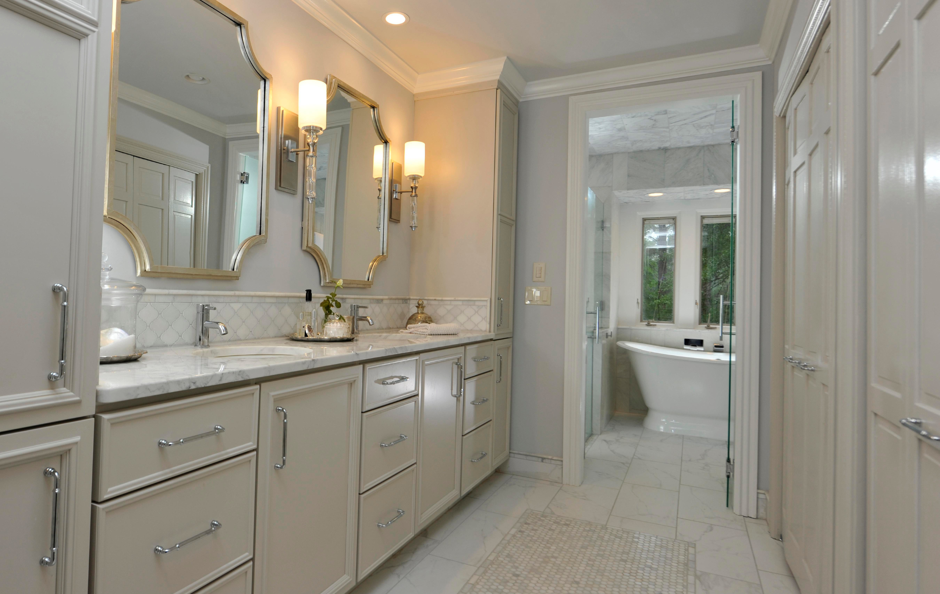 A bathroom with two sinks , two mirrors , and a bathtub.