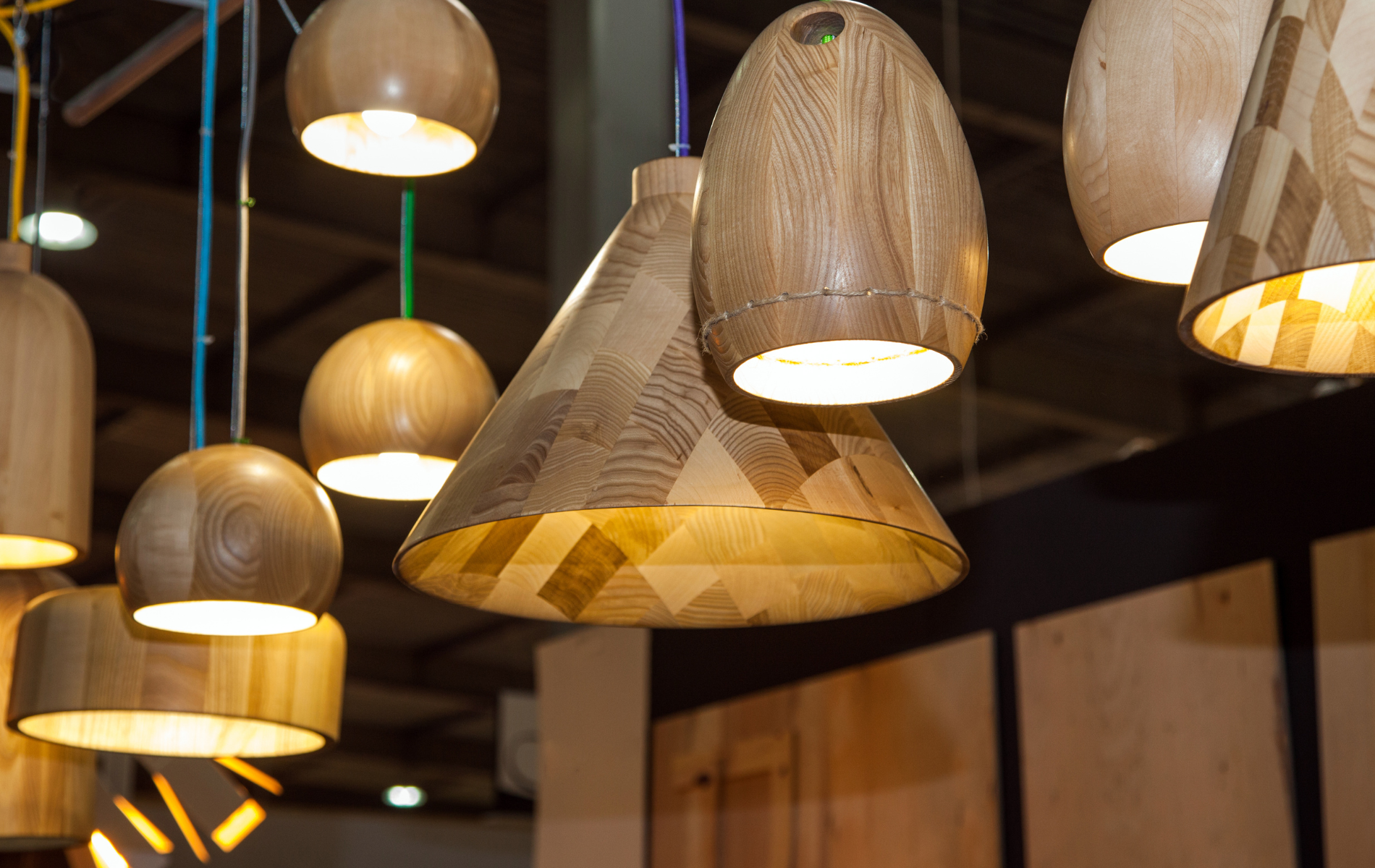 A bunch of wooden pendant lights hanging from the ceiling