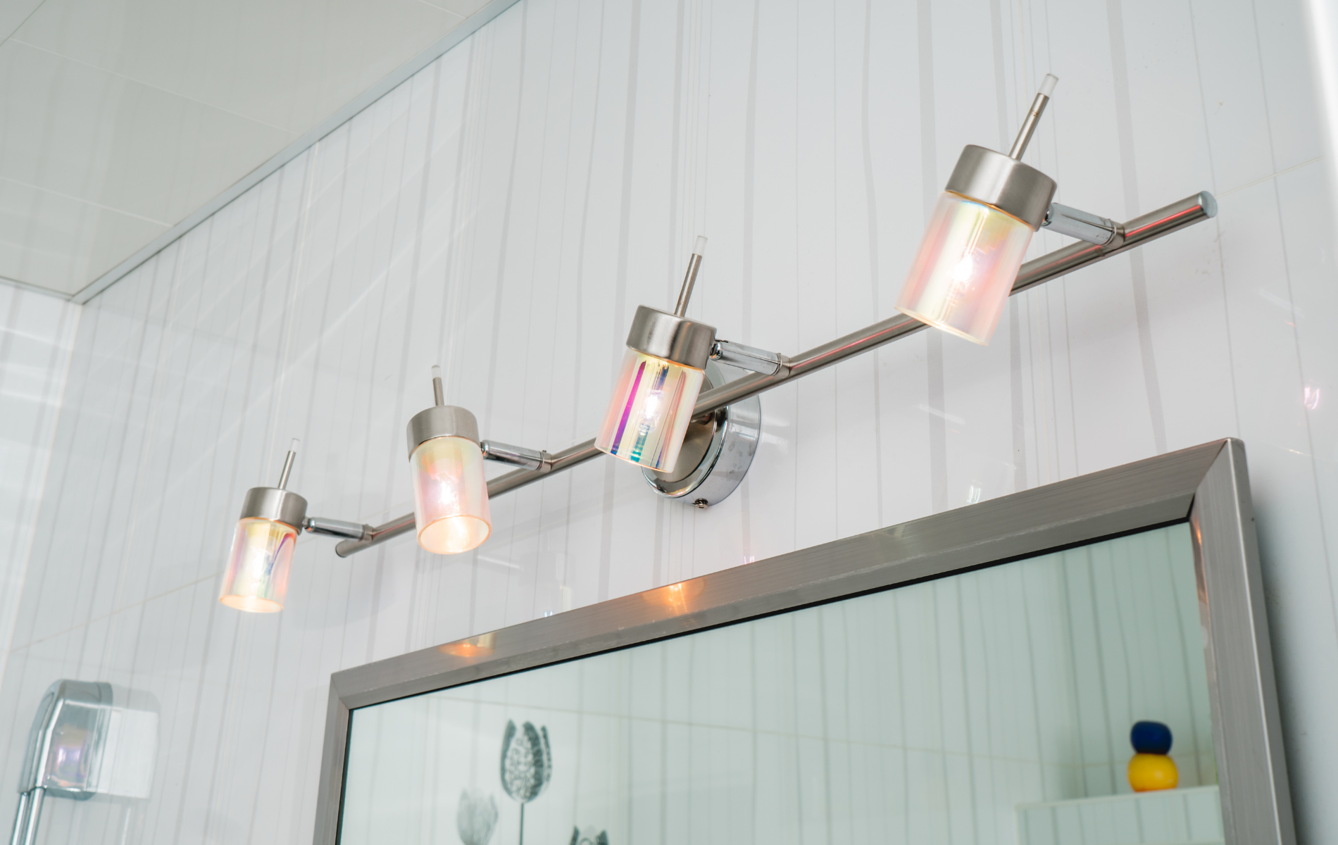 A bathroom with a vanity light and a mirror.