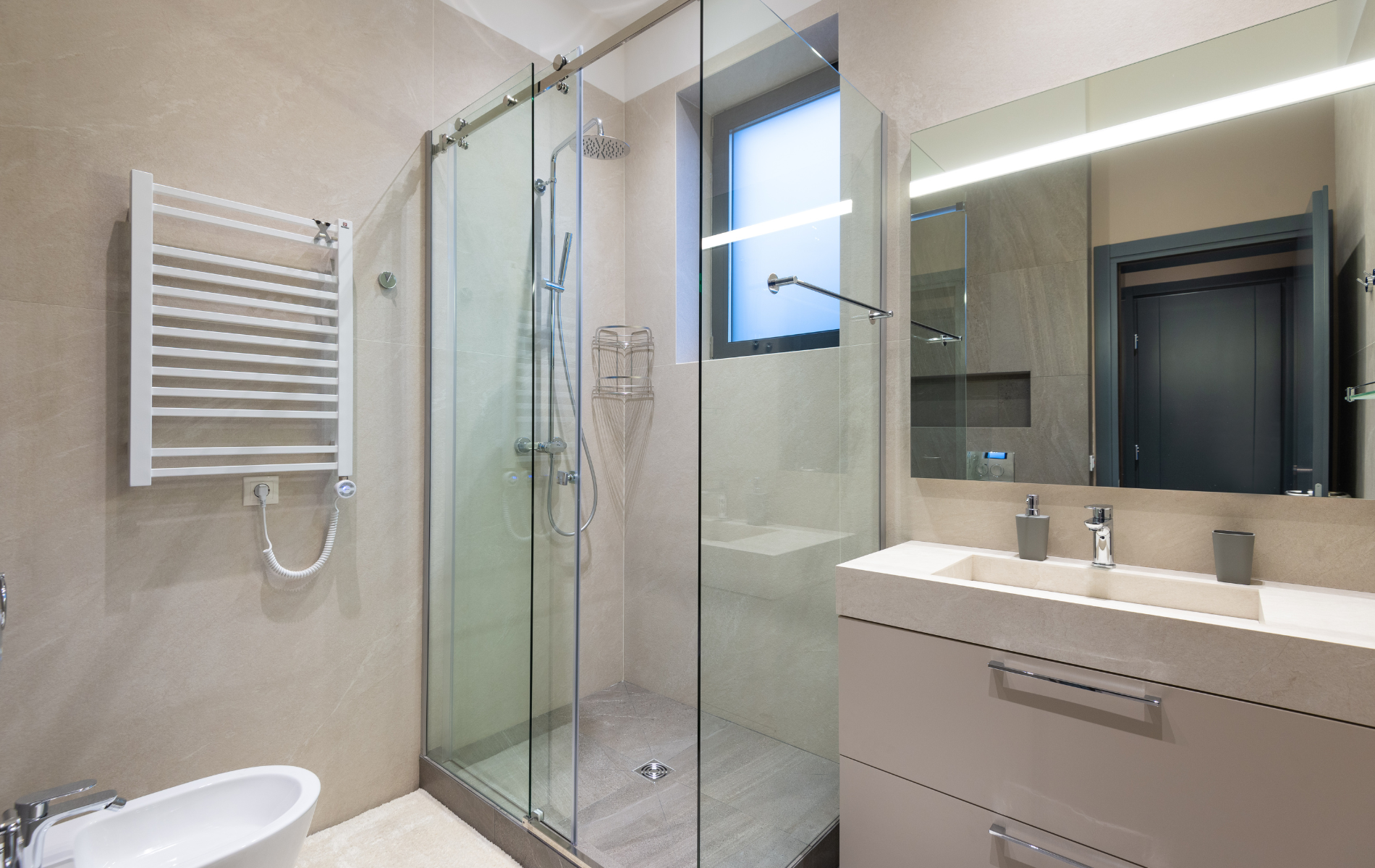 A bathroom with a walk in shower , sink , and mirror.