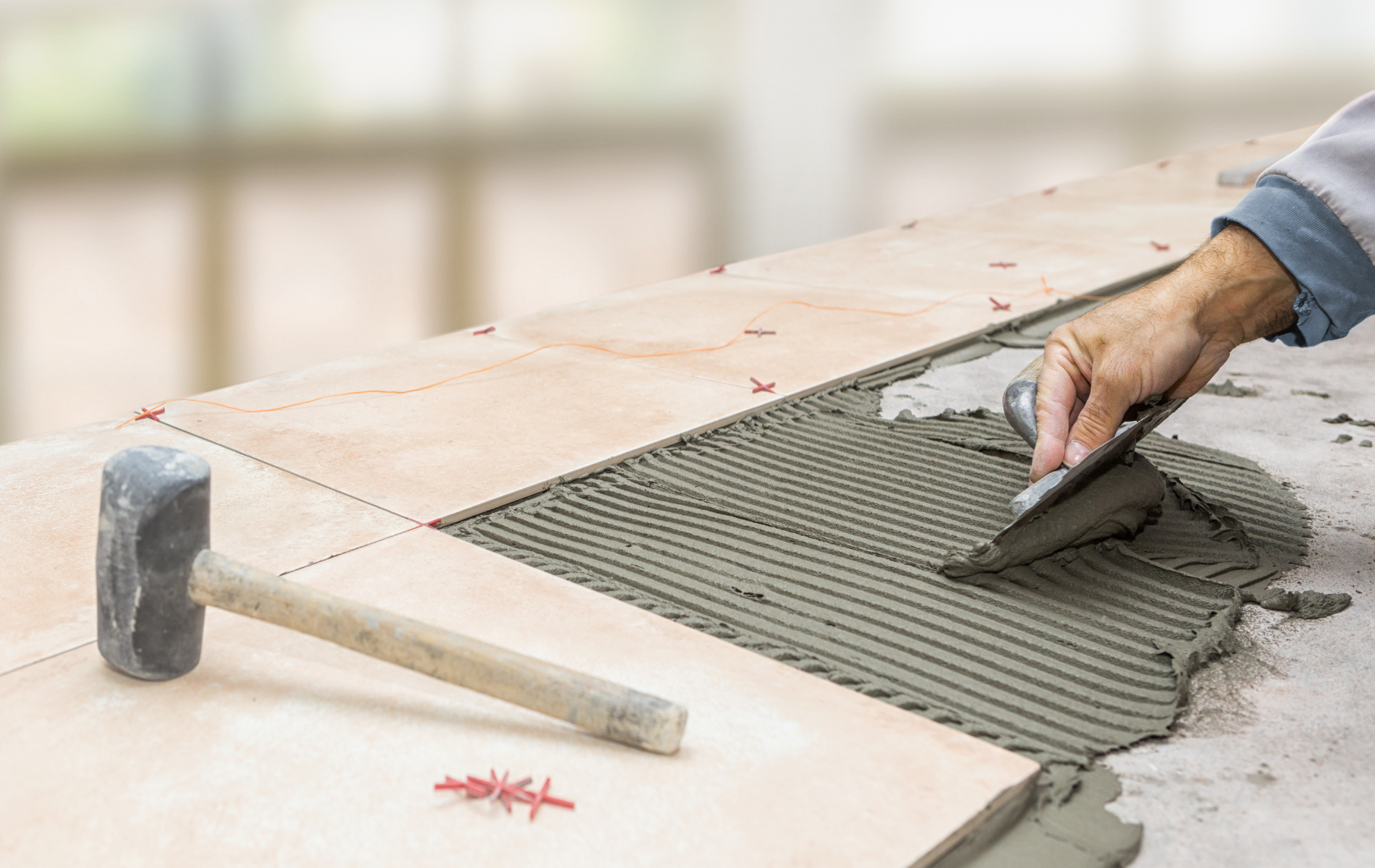 A person is laying a tile on the floor.