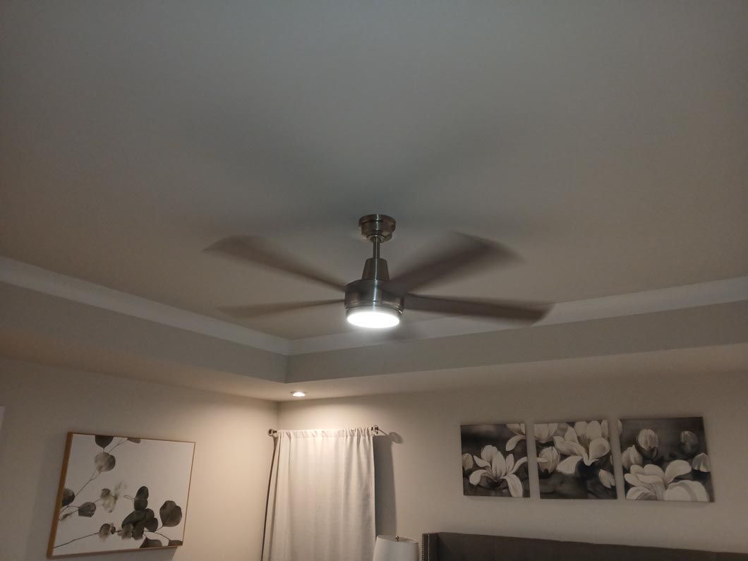 A ceiling fan is hanging from the ceiling in a bedroom