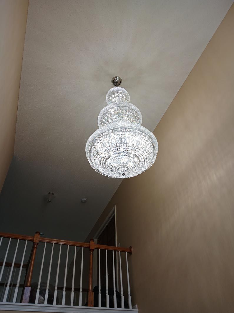 A chandelier is hanging from the ceiling above a staircase