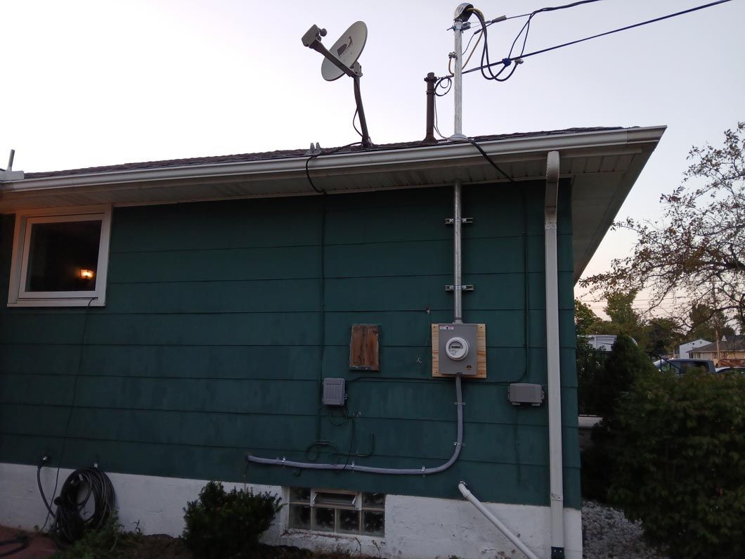 A blue house with a satellite dish on top of it
