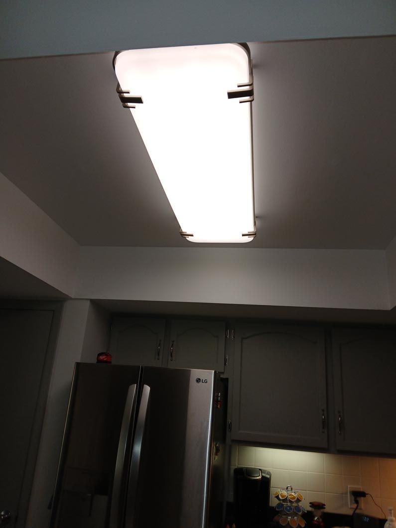 A kitchen with a refrigerator and a light on the ceiling