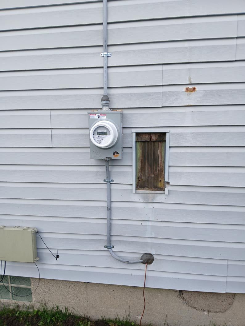 A white house with a meter on the side of it.