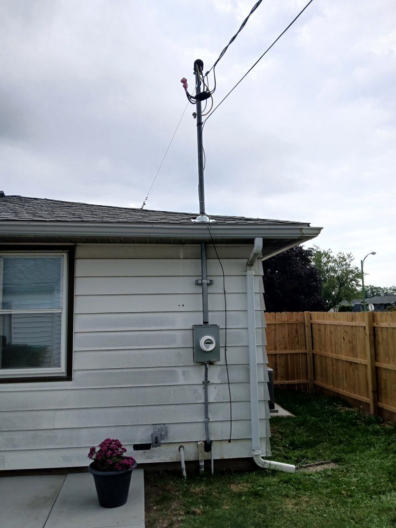 A white house with a telephone pole on the side of it.