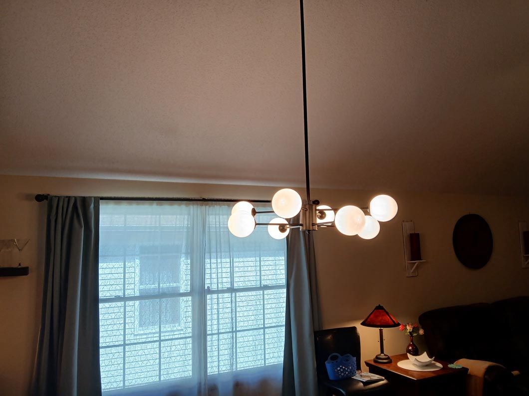 A living room with a chandelier hanging from the ceiling