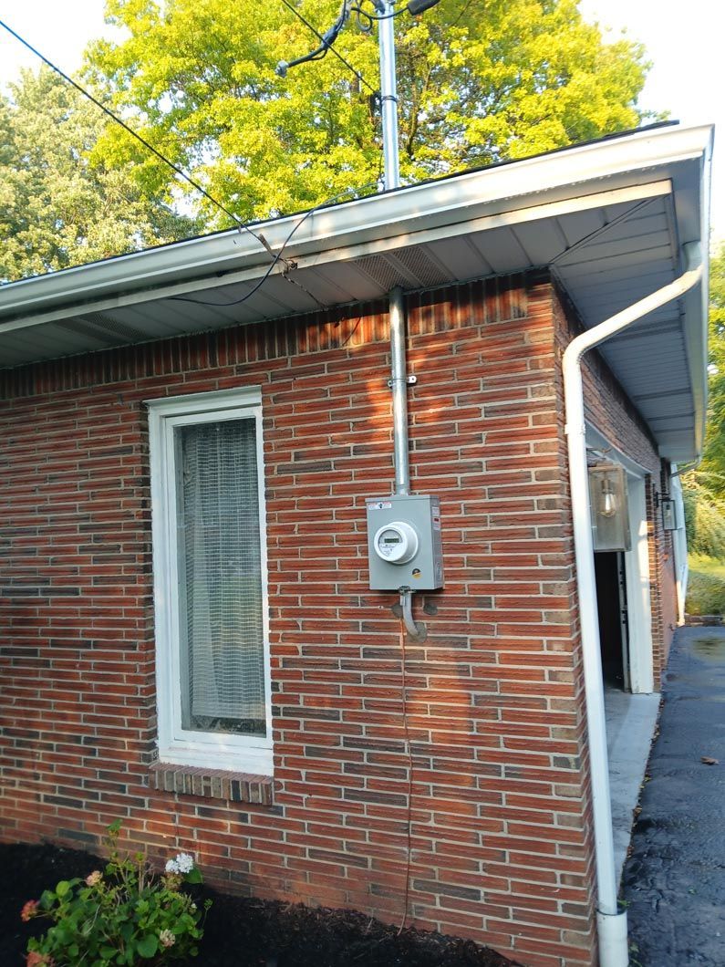 A brick house with a meter on the side of it.