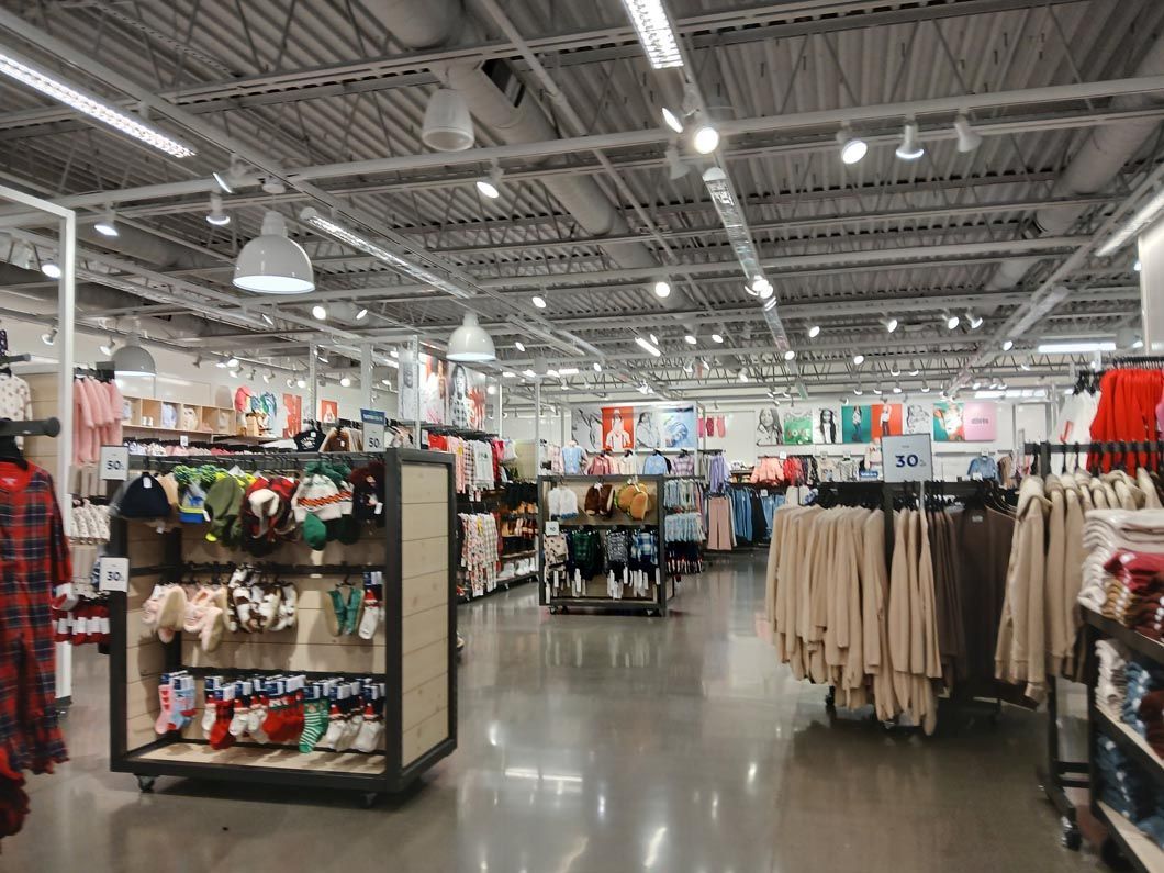 A blurred image of a clothing store filled with lots of clothes.