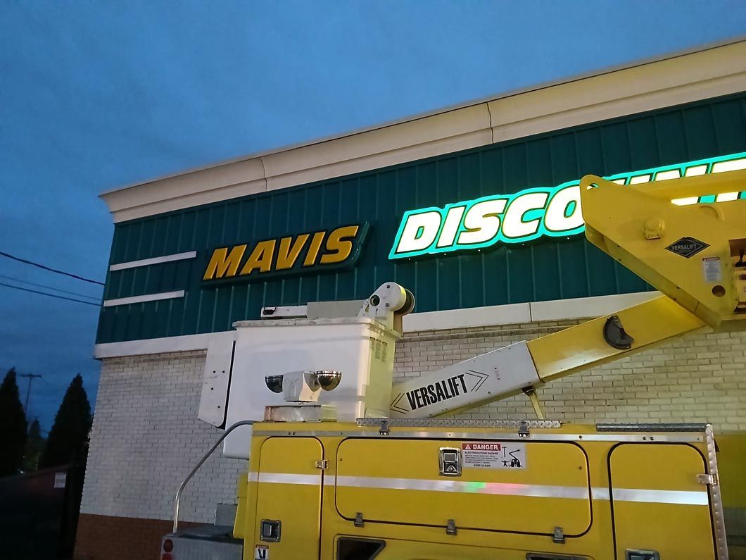 A yellow truck is parked in front of a mavis disco store