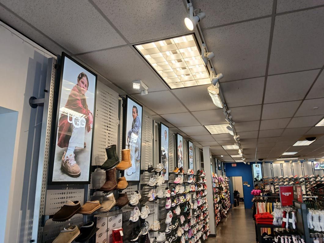 The inside of a shoe store with a lot of shoes on display.