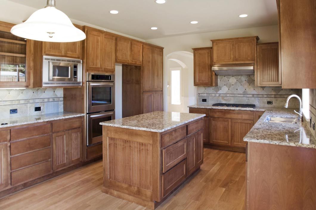 A kitchen with wooden cabinets and granite counter tops