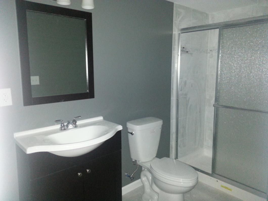 A bathroom with a toilet a sink and a mirror