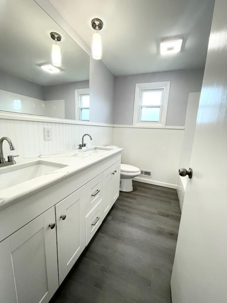 A bathroom with a sink , toilet and mirror.
