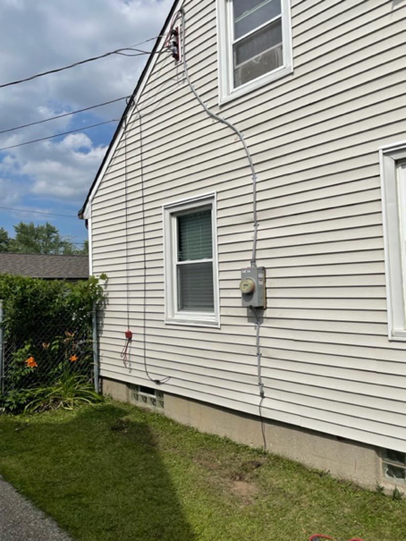 A white house with a telephone pole attached to the side of it.