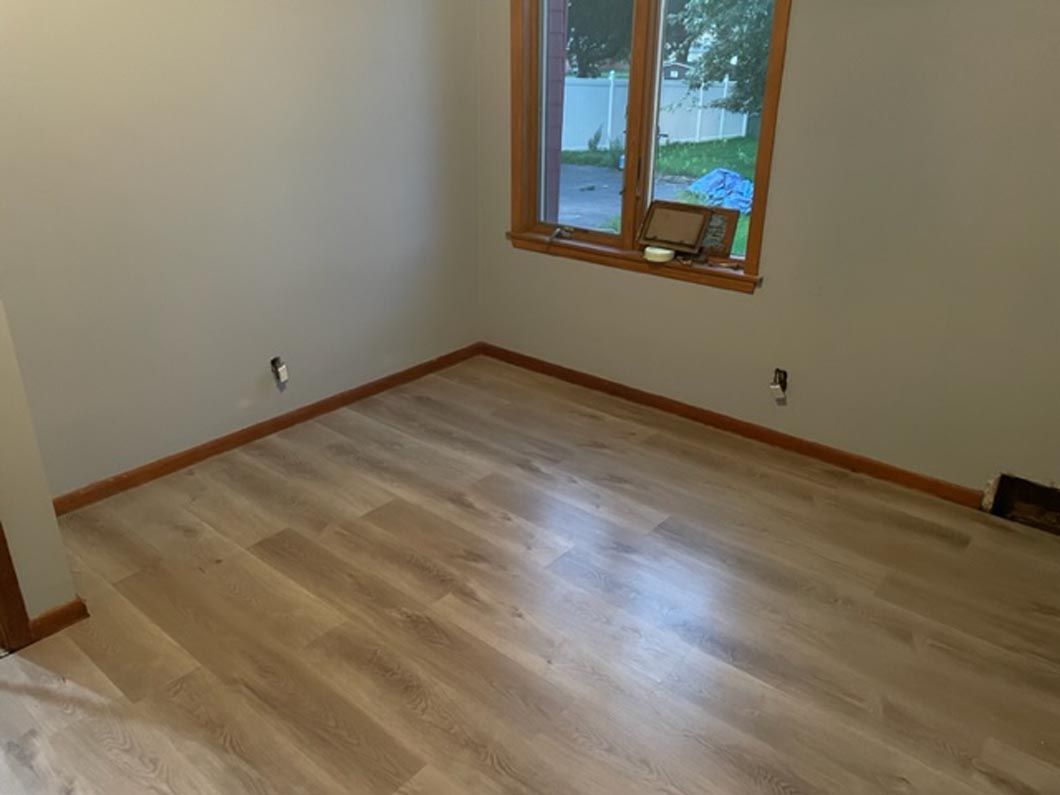 A room with hardwood floors and a window.