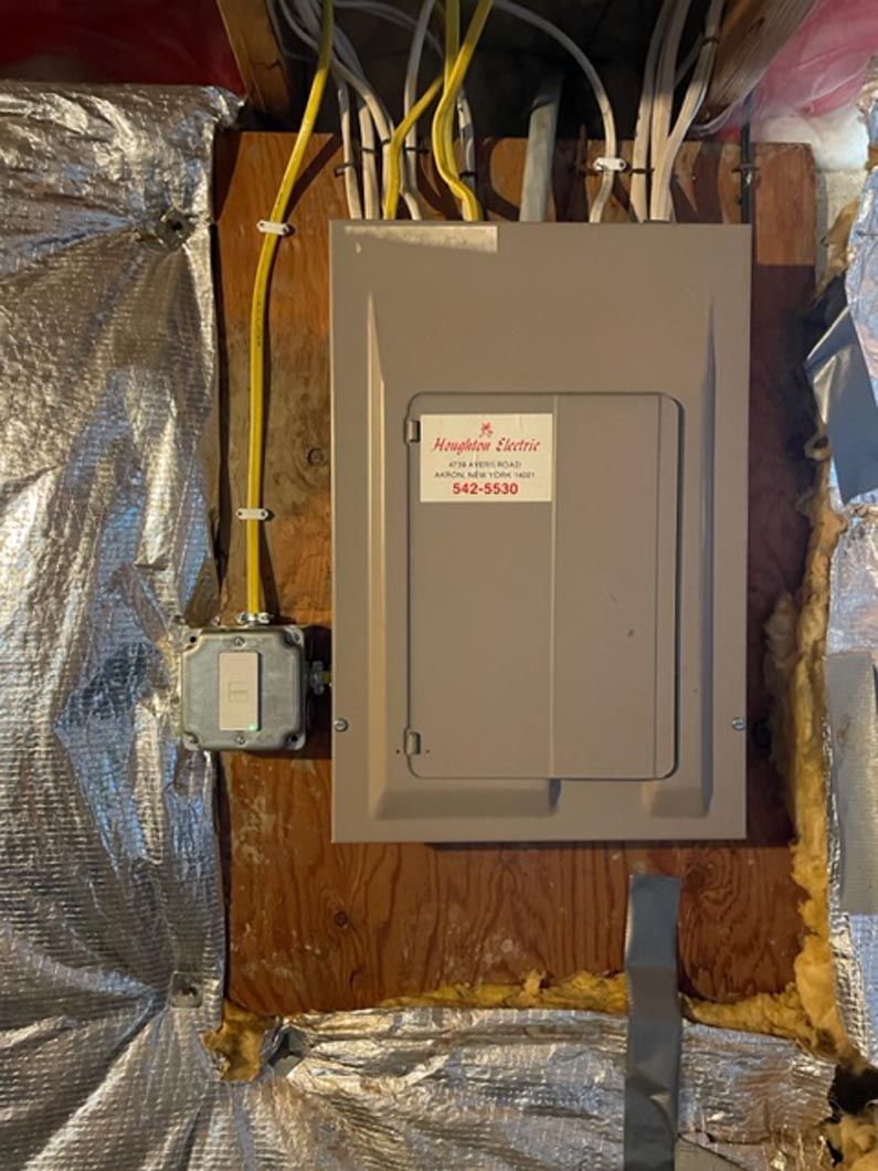 A electrical box is sitting on top of a wooden wall.