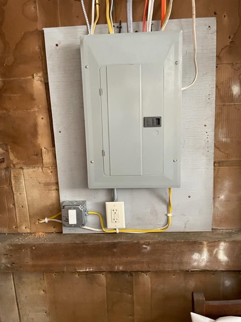 A electrical box is hanging on a wall in a room.