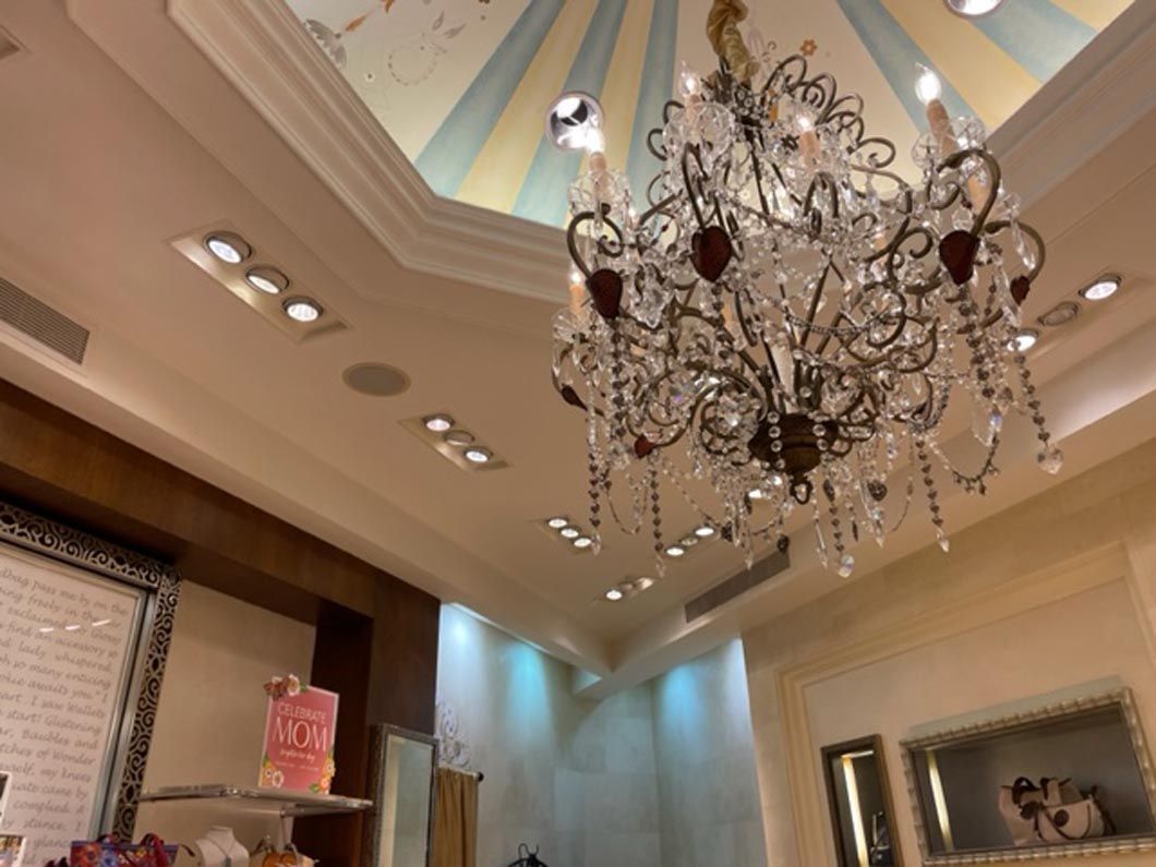 A large chandelier hangs from the ceiling of a room