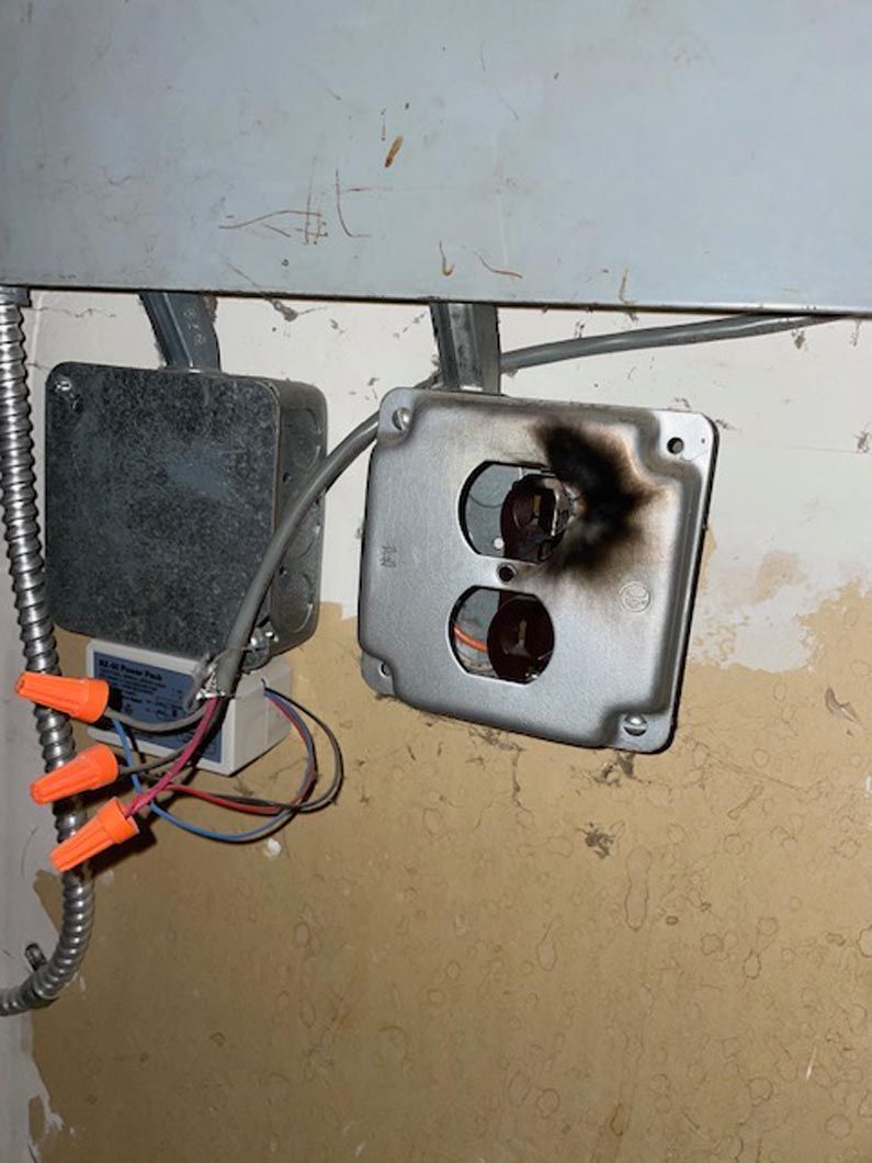 A close up of a broken electrical outlet on a wall.