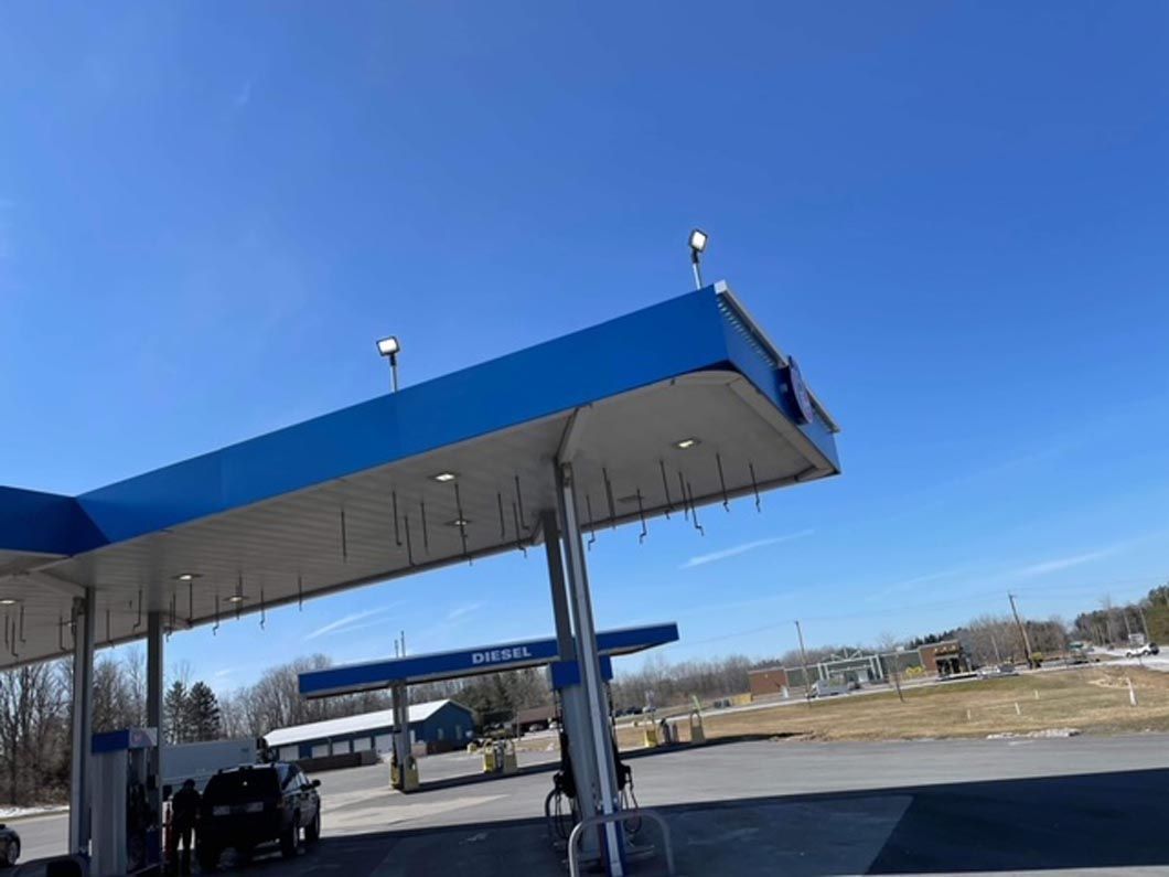 A blue and white gas station with a blue sky in the background.