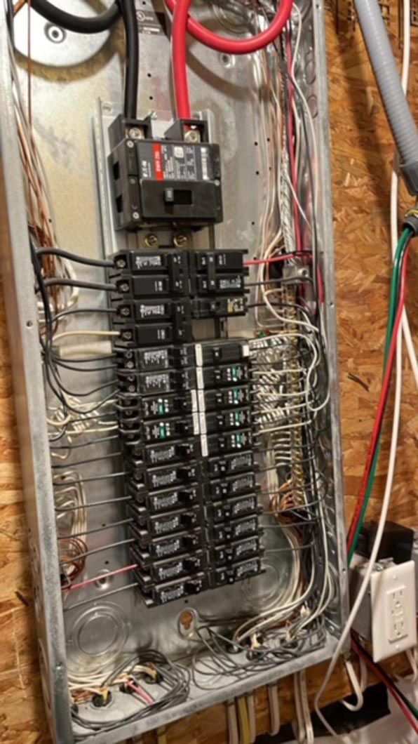 A close up of a electrical panel with a lot of wires coming out of it.