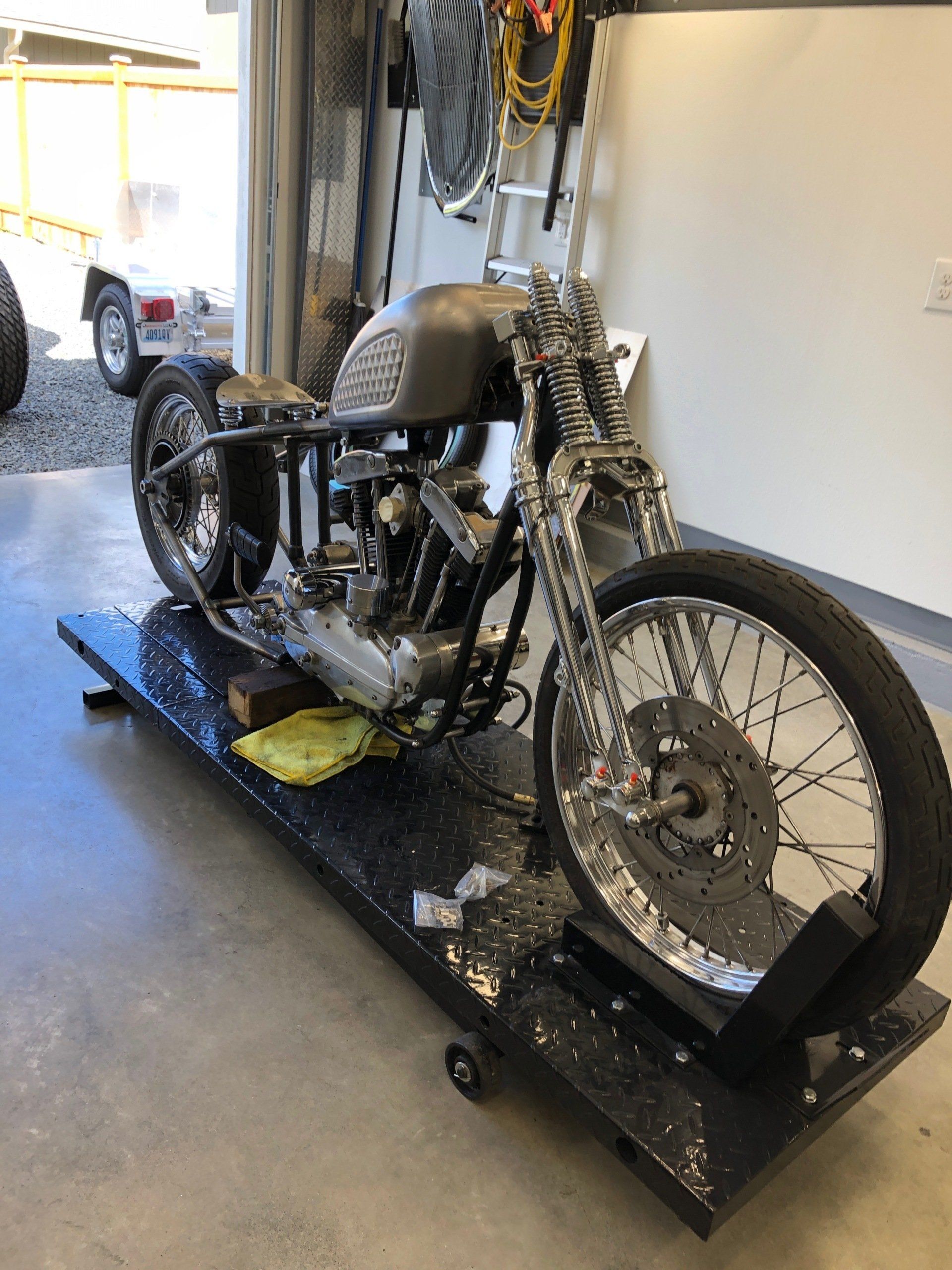 A motorcycle is sitting on a ramp in a garage.