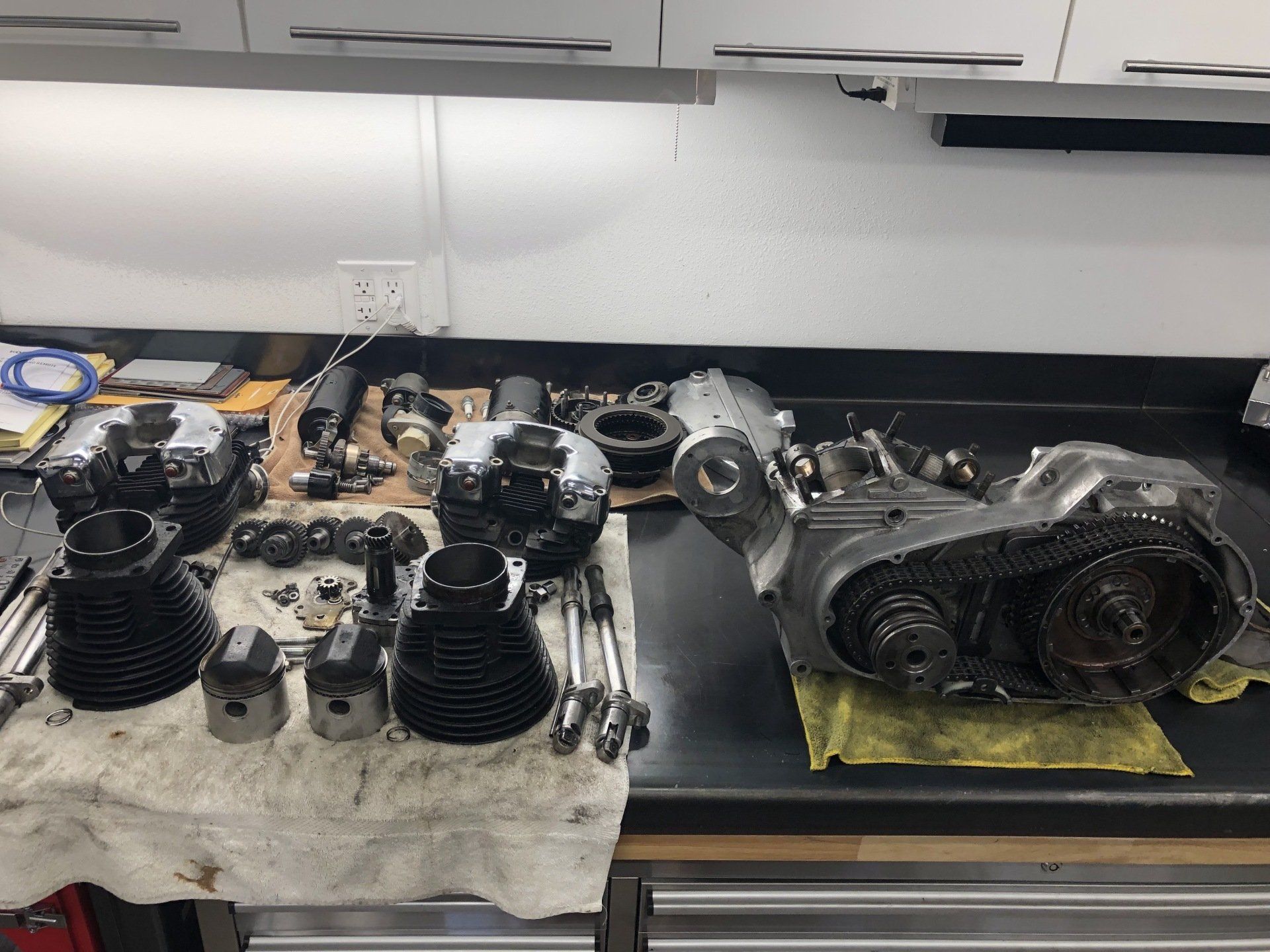 A motorcycle engine is sitting on a counter in a garage