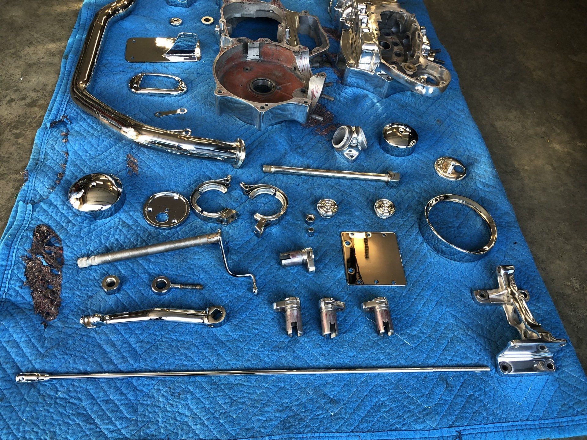 A bunch of chrome parts on a blue blanket
