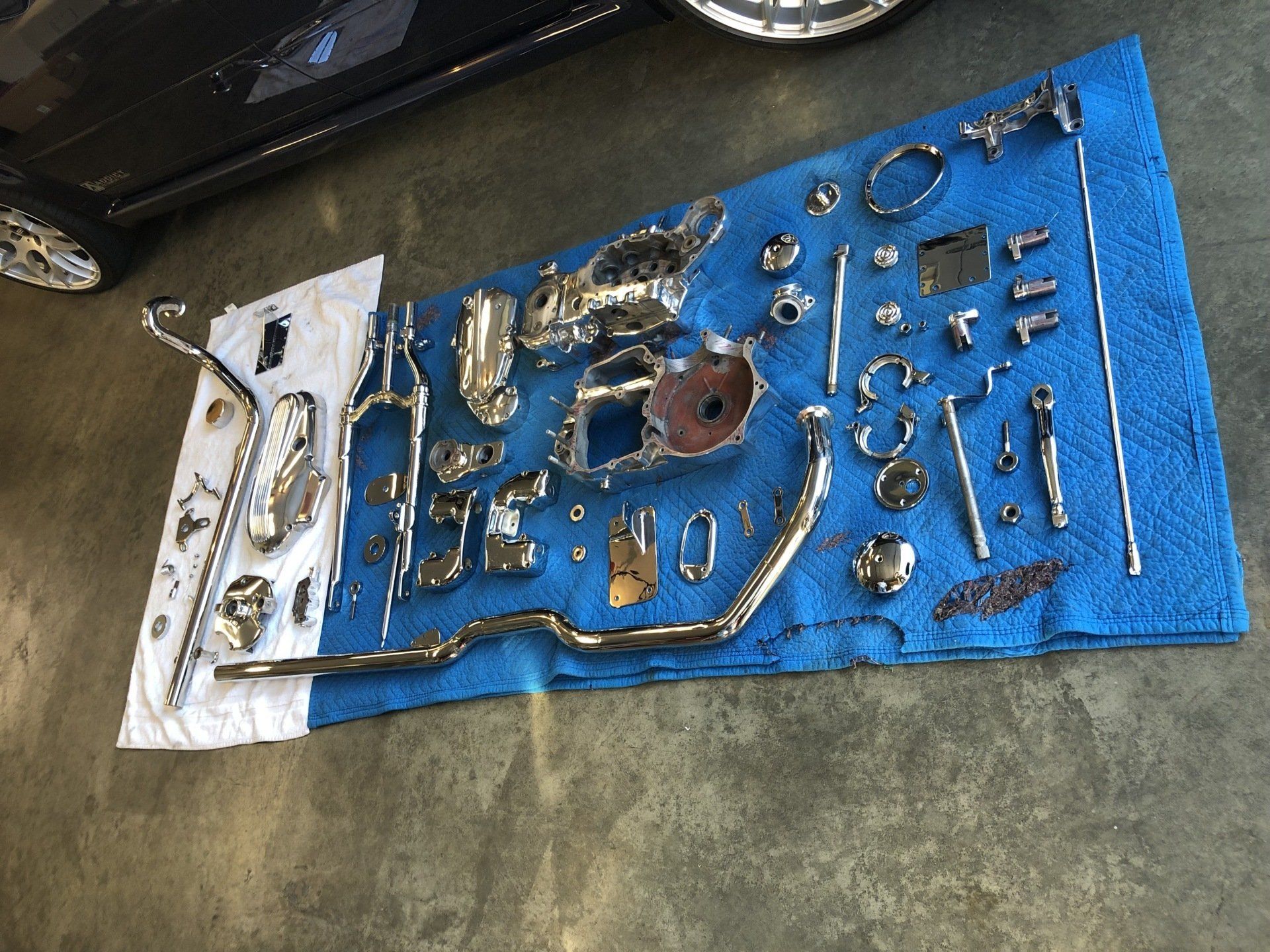 A bunch of metal parts are laying on a blue towel