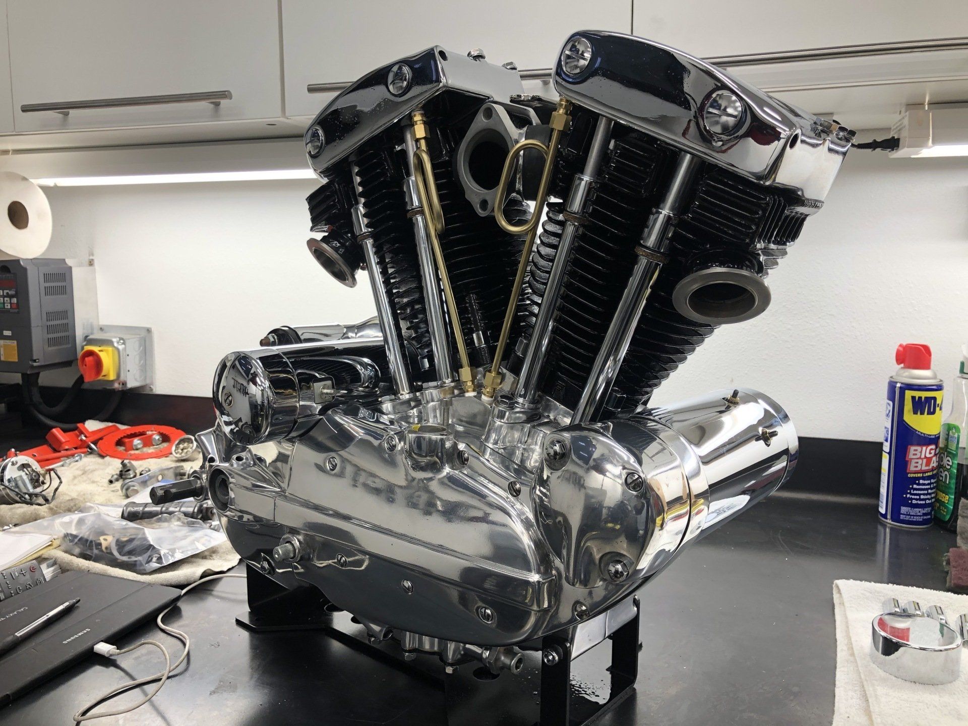 A motorcycle engine is sitting on a table next to a bottle of wd-40