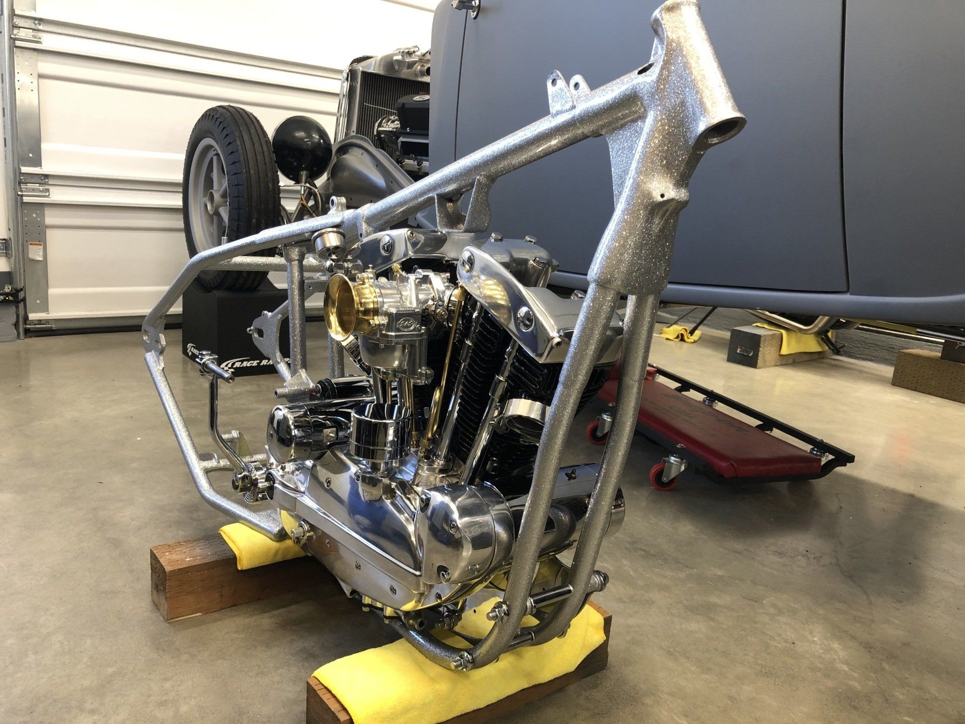 A motorcycle is sitting on a wooden block in a garage.