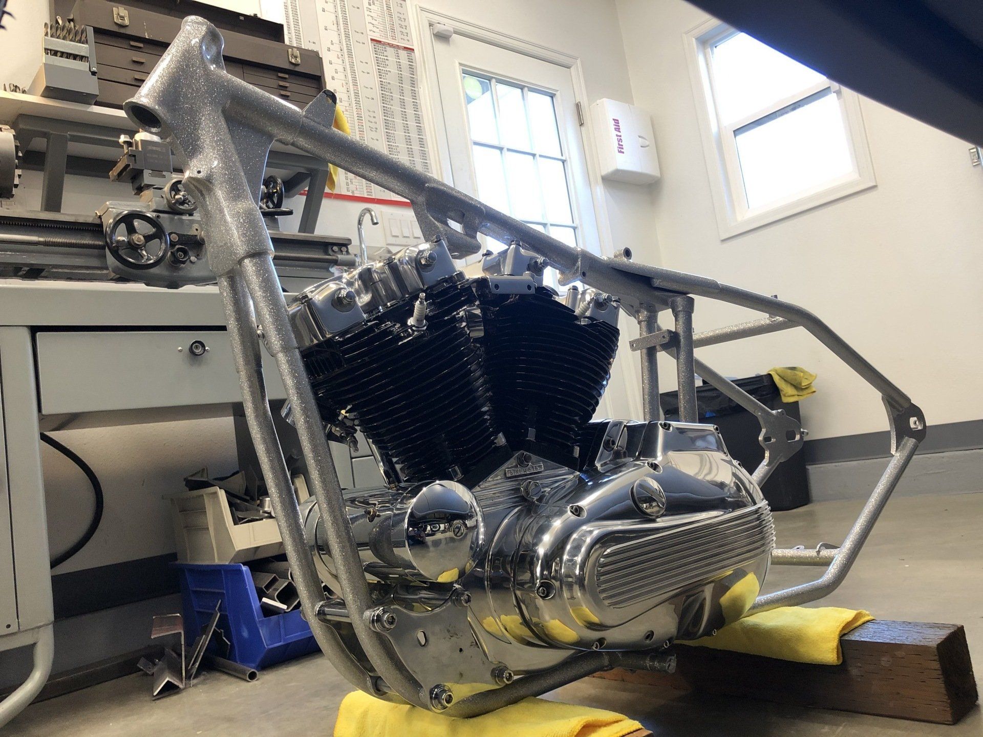 A motorcycle is being built in a room with the number 1 on the wall