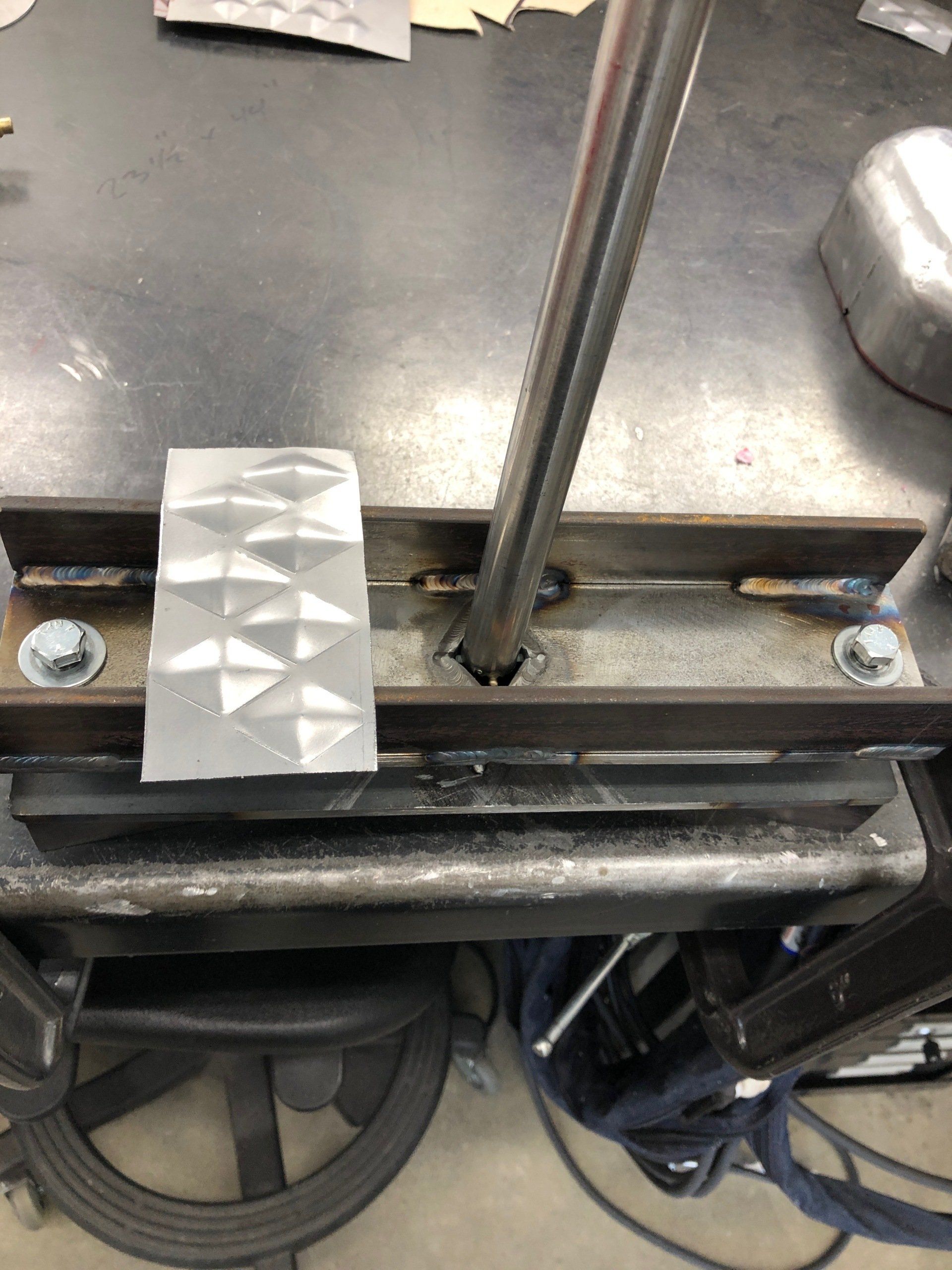 A piece of metal is sitting on top of a metal table.