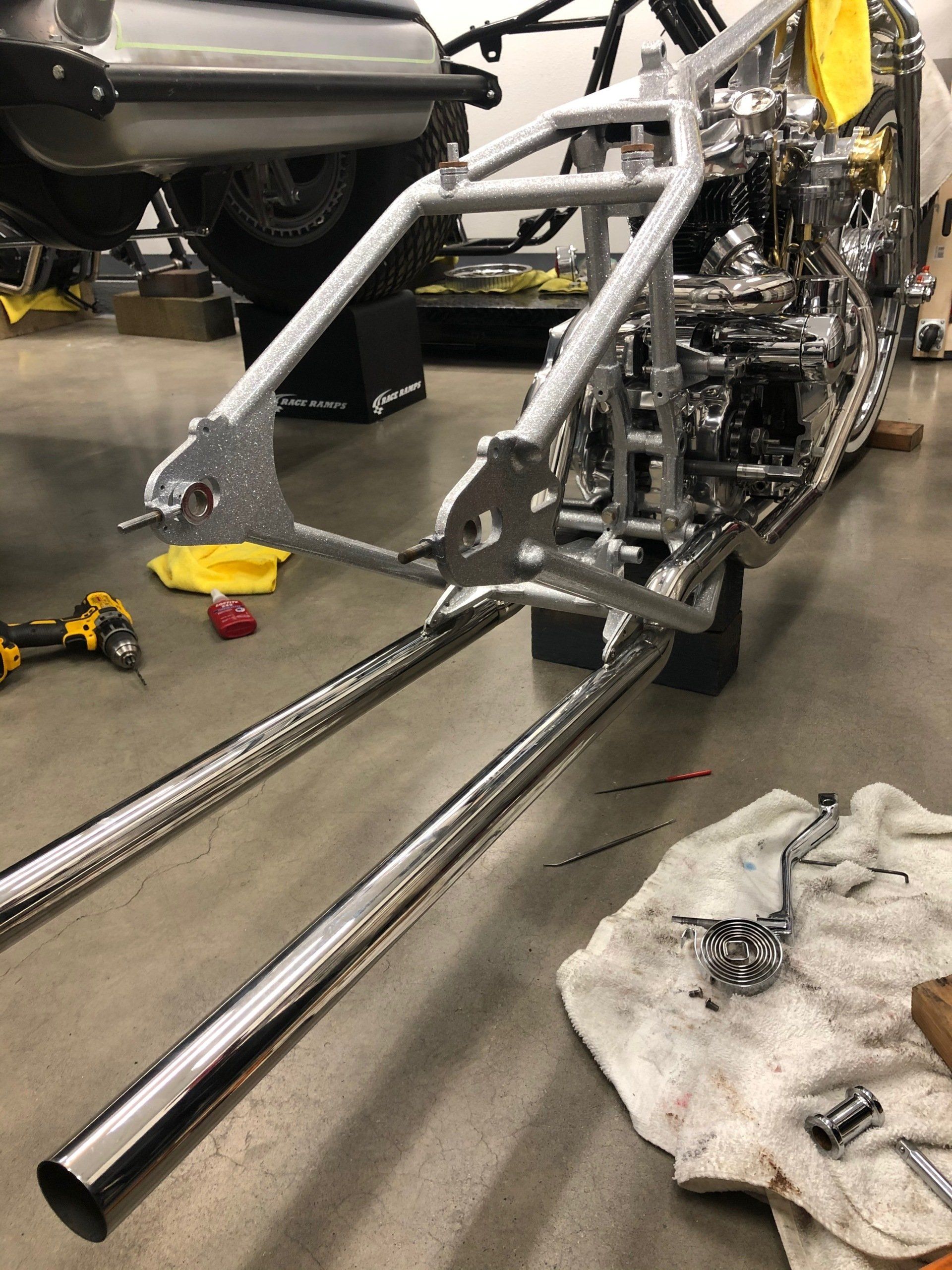 A motorcycle frame is being built in a garage.