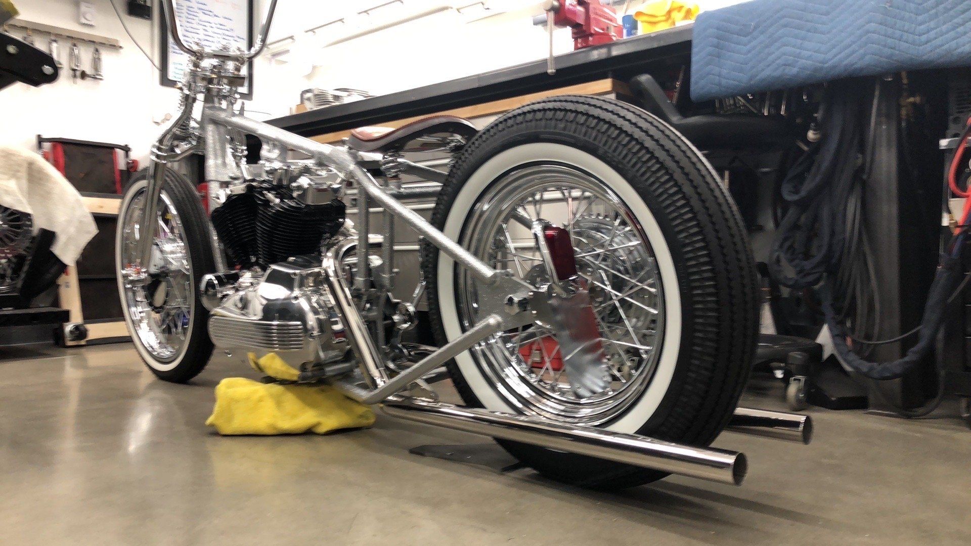 A motorcycle is sitting on a yellow block in a garage.