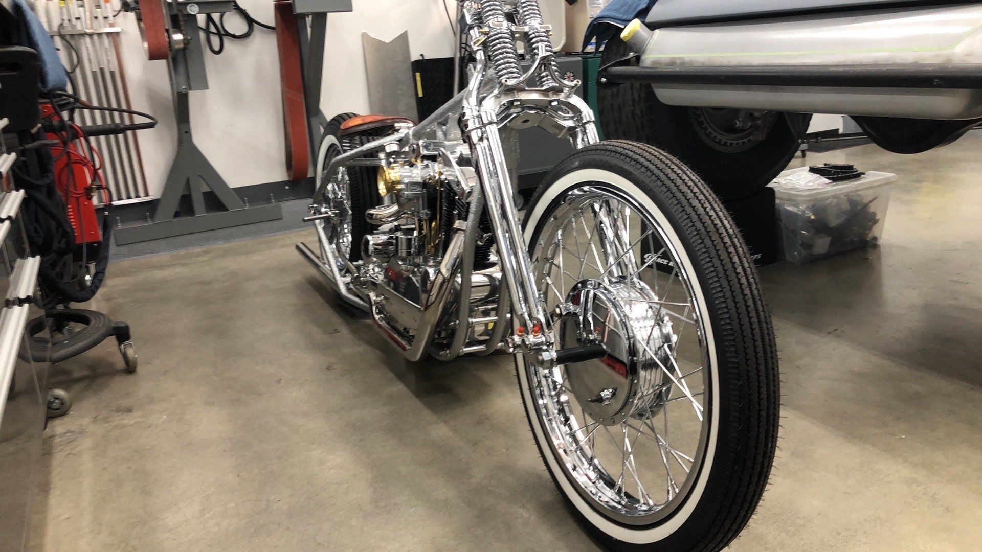 A motorcycle is parked in a garage next to a car.