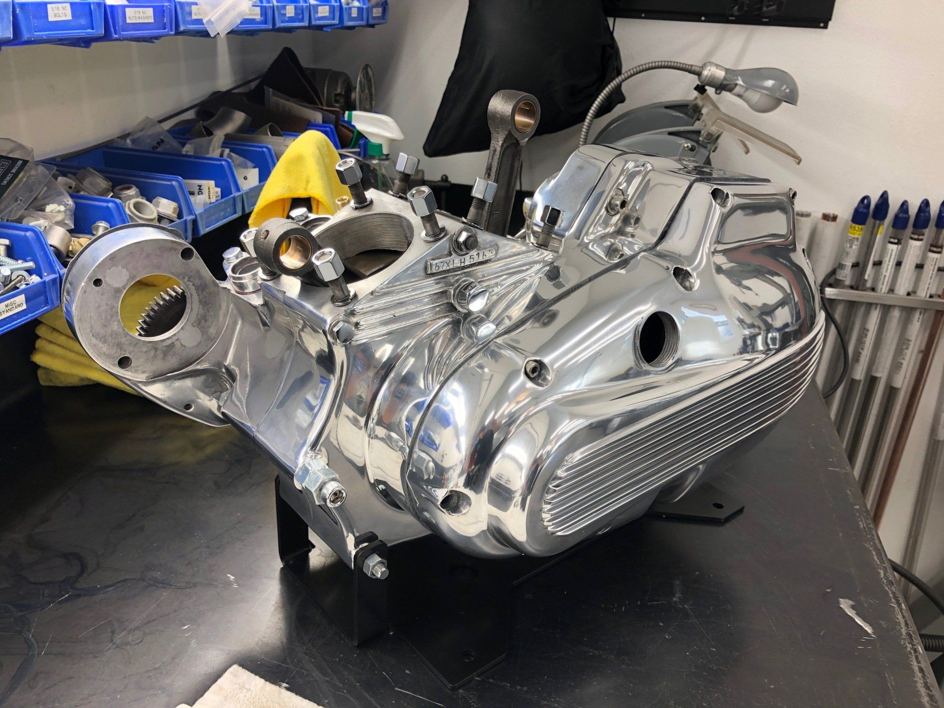 A motorcycle engine is sitting on a table in a garage.