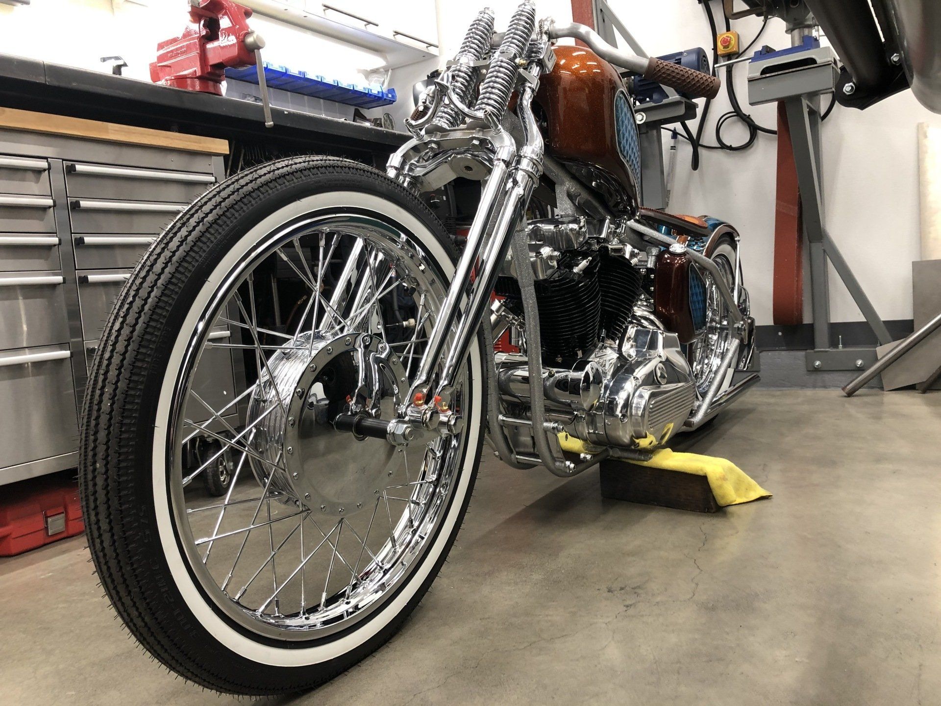 A motorcycle with white tires is parked in a garage.