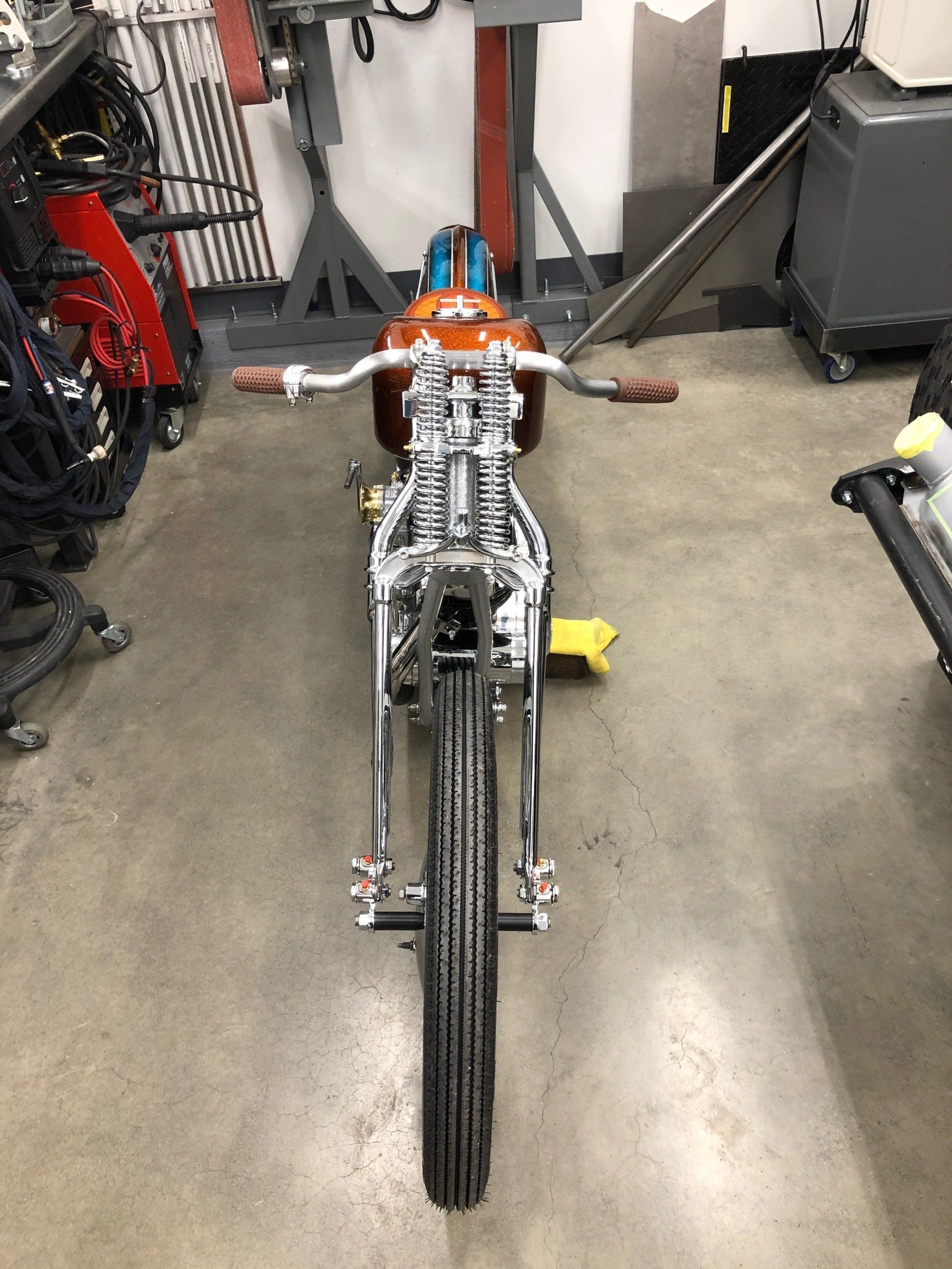 A motorcycle is sitting on a concrete floor in a garage.