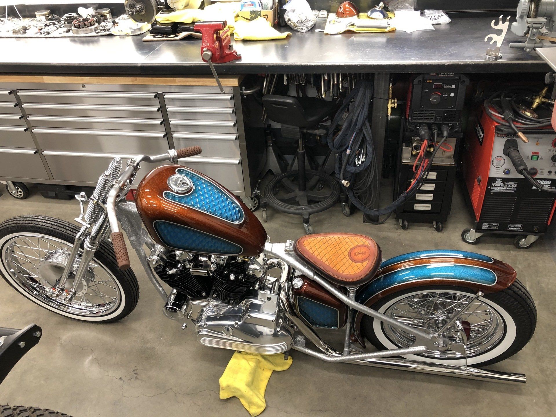 A motorcycle is parked in a garage next to a workbench.
