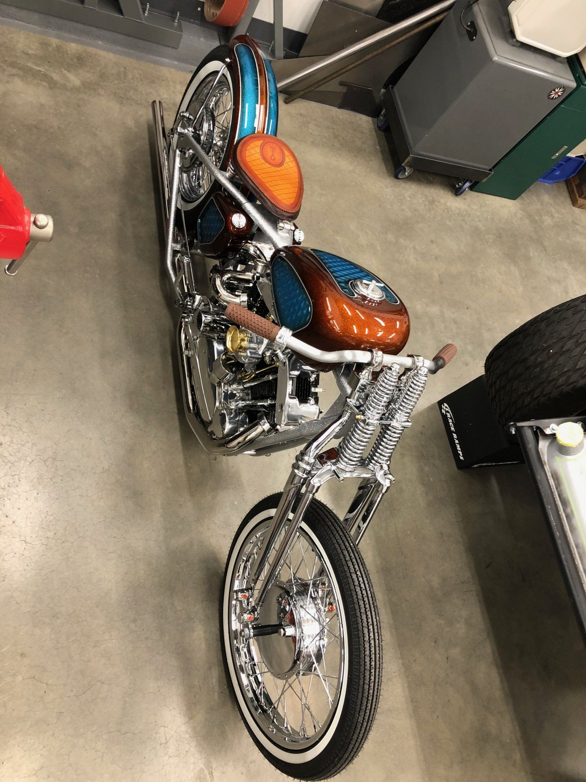 A motorcycle is parked on a concrete floor in a garage.
