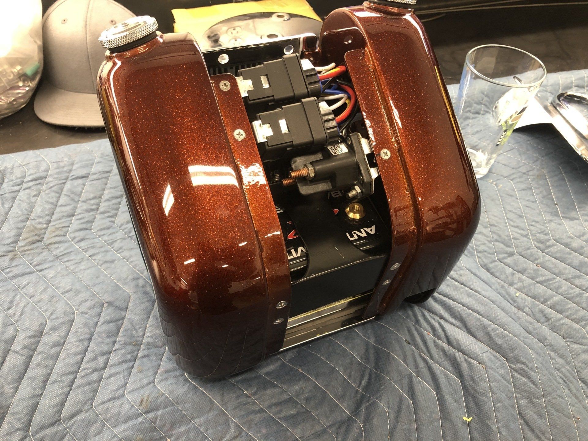 A brown metallic object is sitting on a blue blanket