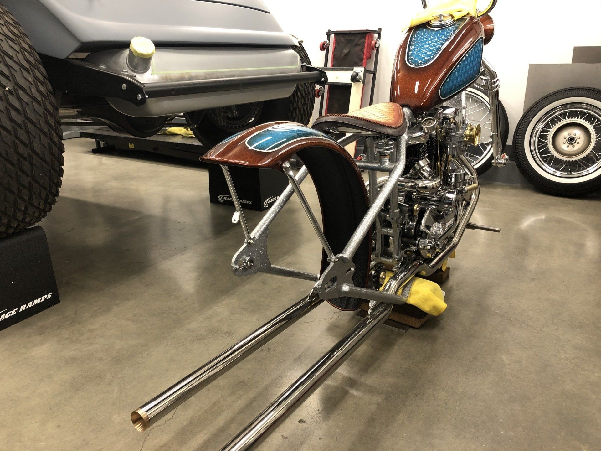 A motorcycle is sitting on a concrete floor in a garage.