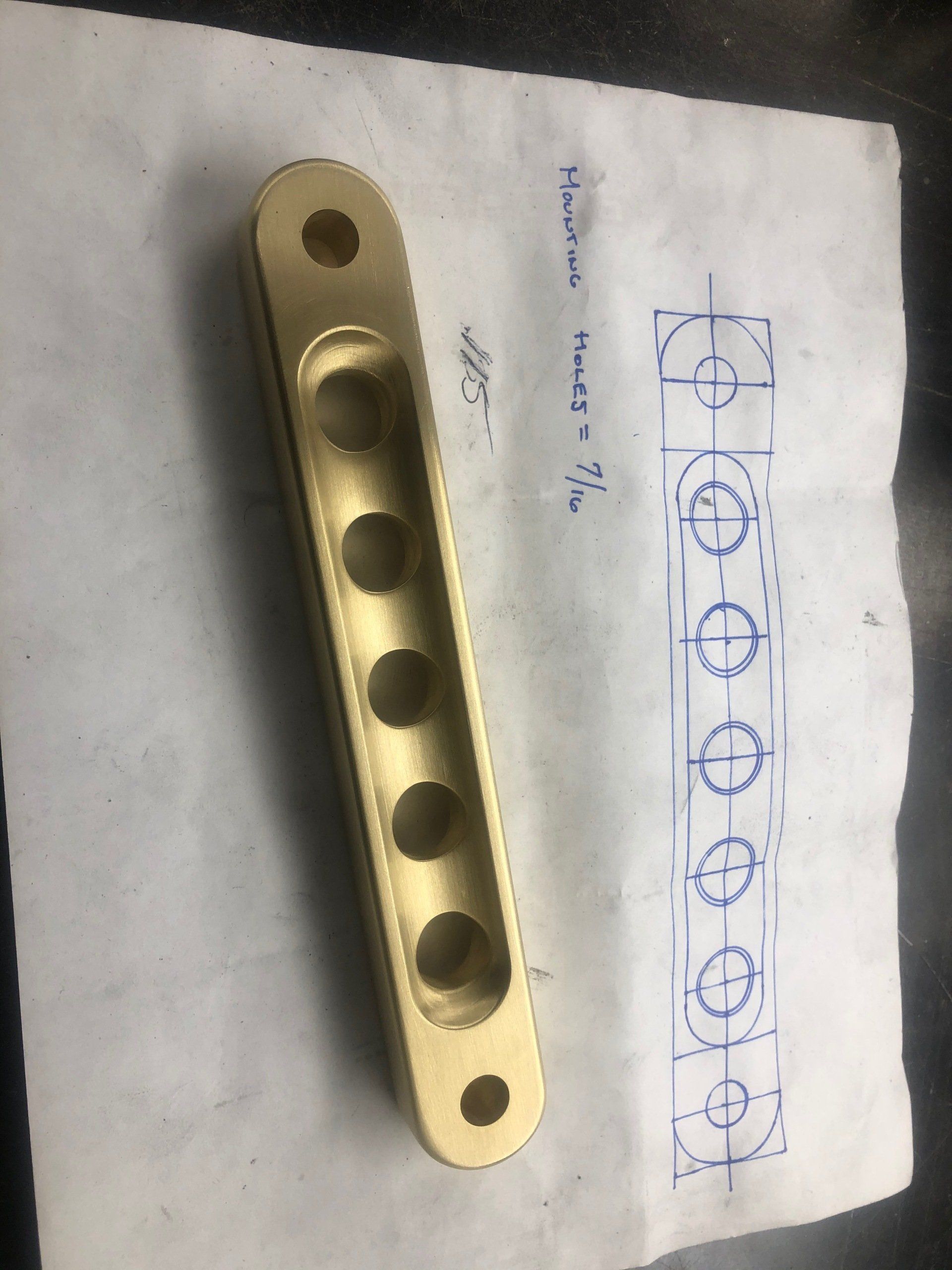 A piece of brass is sitting on top of a piece of paper