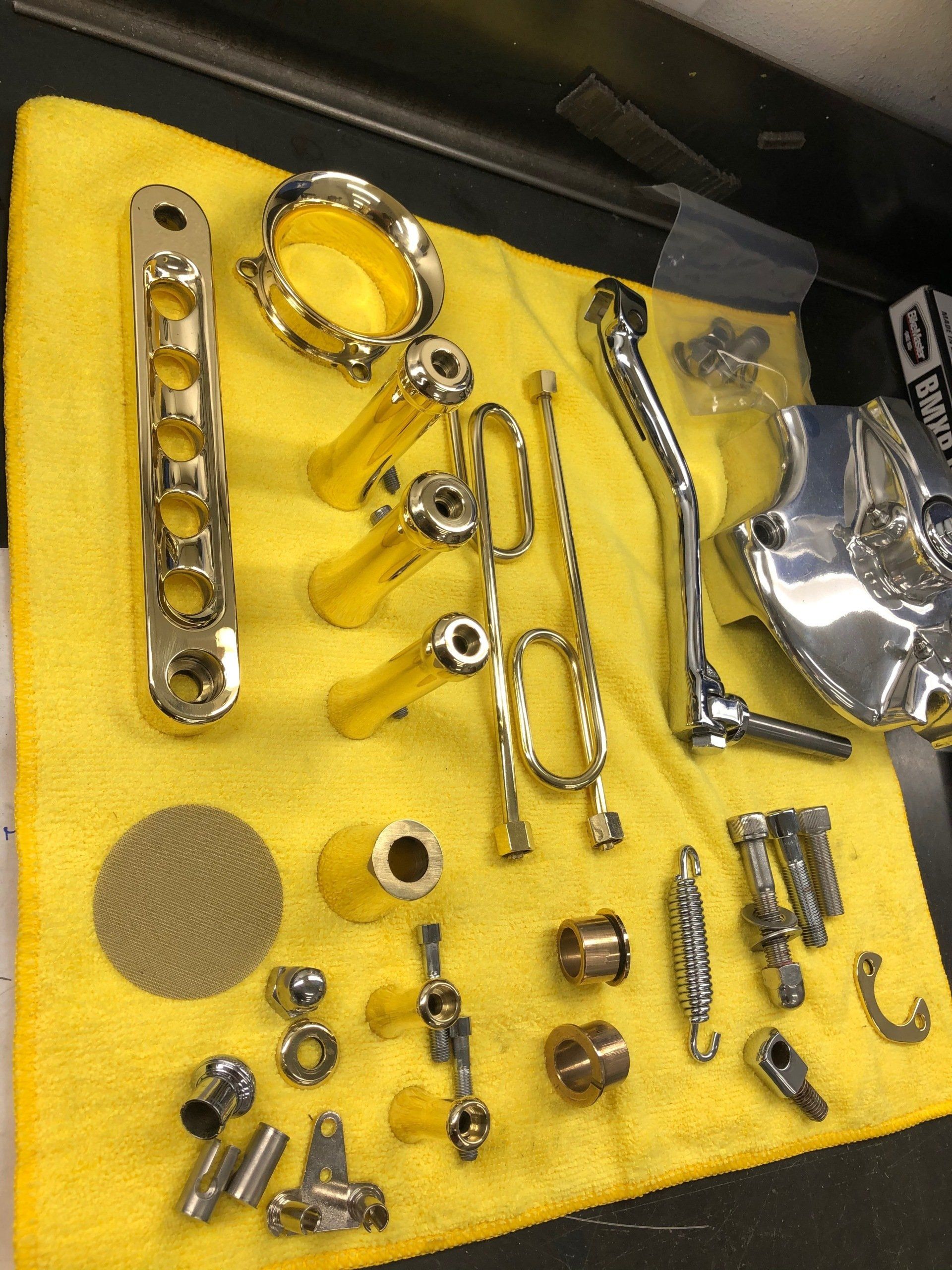 A bunch of chrome parts on a yellow towel