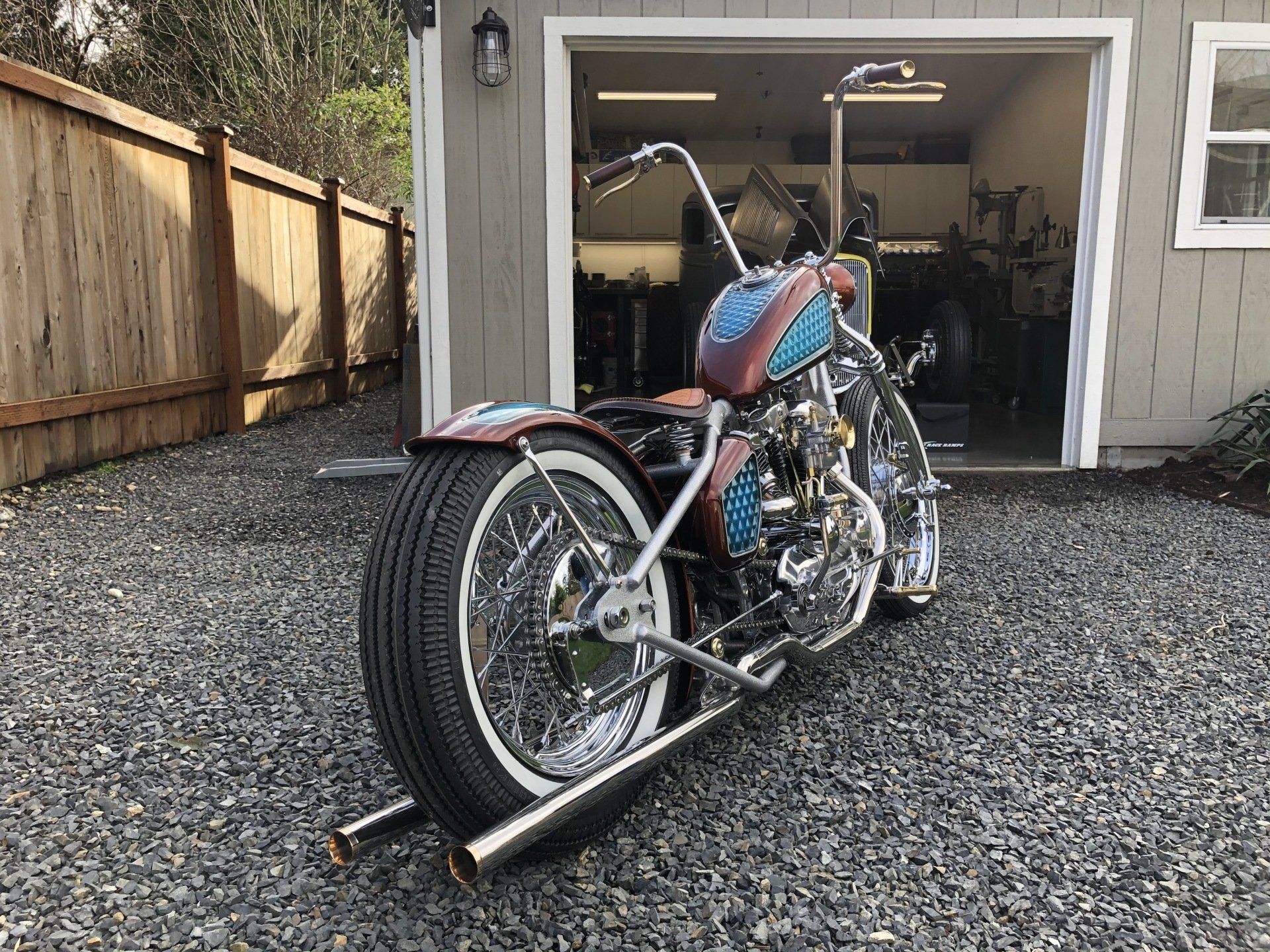A motorcycle is parked in front of a garage.