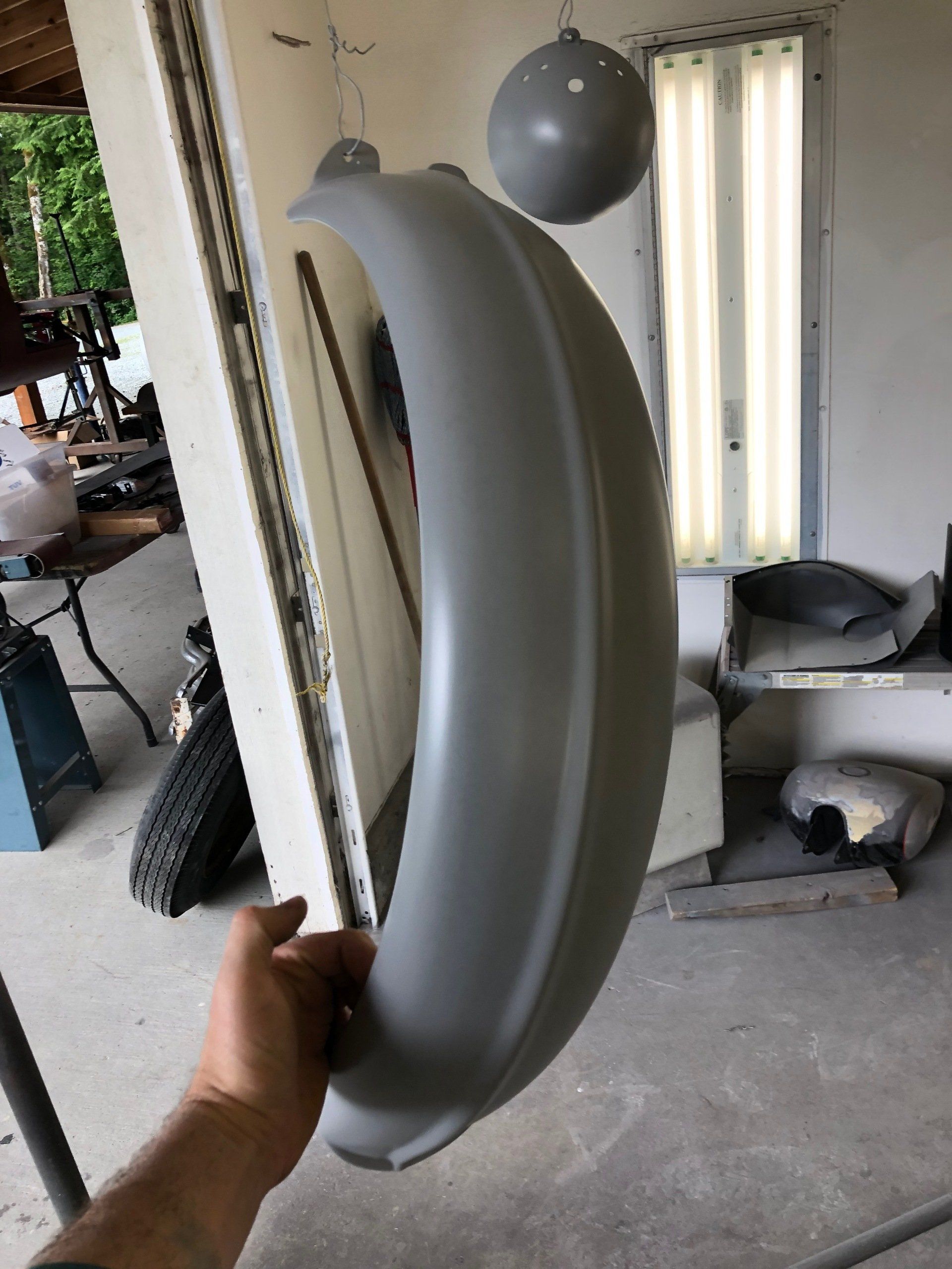 A person is holding a large gray object in their hand