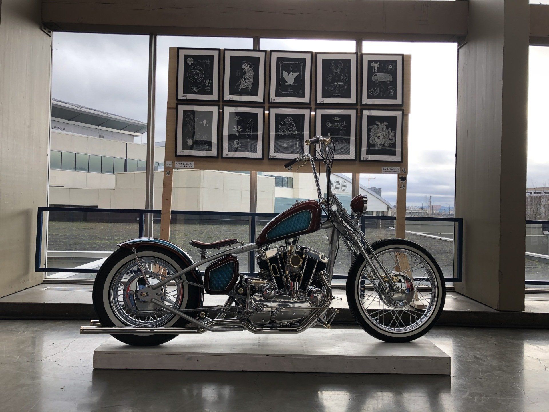 A motorcycle is on display in front of a window in a room.